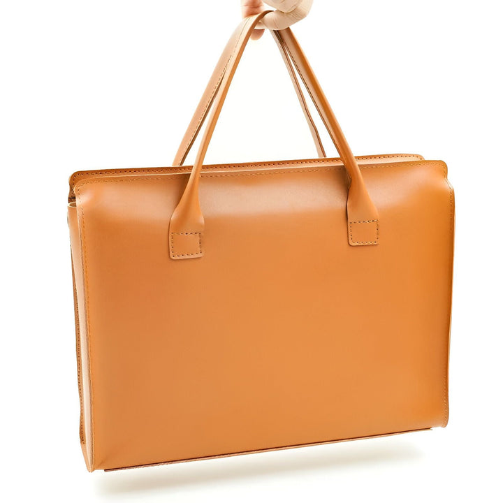 Sac porte-documents en cuir marron clair tenu par la main., 46193907532000,46193907564768,46193907597536,46193907630304,46193907663072,46193907695840,46193907728608,46193907761376,46193907826912,46193907859680,46193907892448,46193907925216,46193907957984,46193907990752,46193908023520