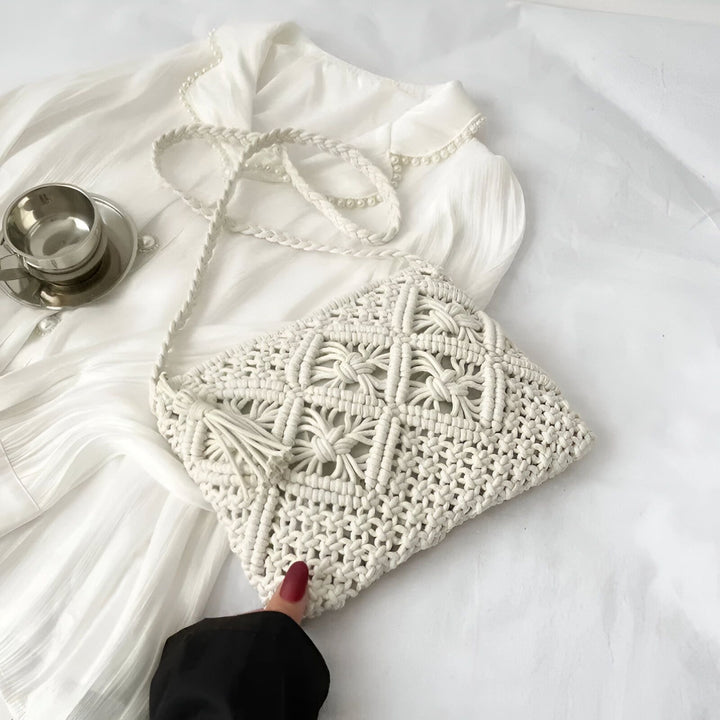 Sac macramé blanc tressé, main tenant la bandoulière, sur chemise blanche., 46193947640032,46193947672800,46193947705568