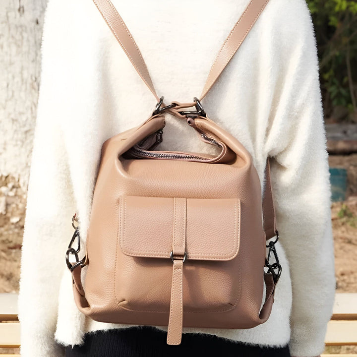 Sac à dos en cuir couleur taupe porté sur le dos avec un pull blanc., 46193840029920,46193840062688,46193840095456,46193840128224,46193840160992
