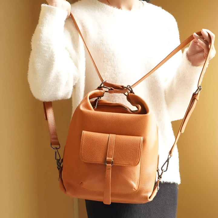 Sac à dos convertible en cuir camel porté par une personne en pull blanc., 46193840029920,46193840062688,46193840095456,46193840128224,46193840160992