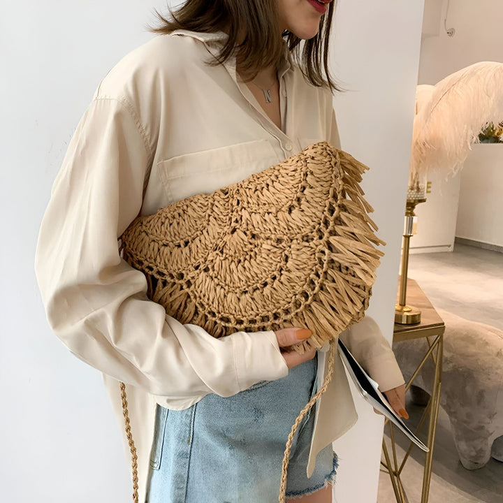 Sac pochette en paille tressée avec franges et chaîne dorée porté par une femme., 46193921884384,46193921917152