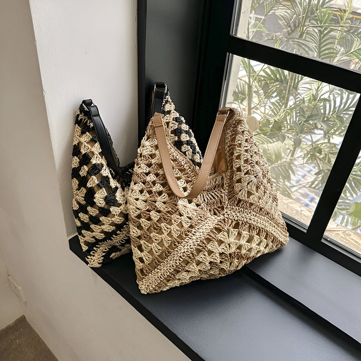 Deux sacs cabas ajourés en paille, noir/beige et marron/beige, sur un rebord de fenêtre., 46193948721376,46193948754144