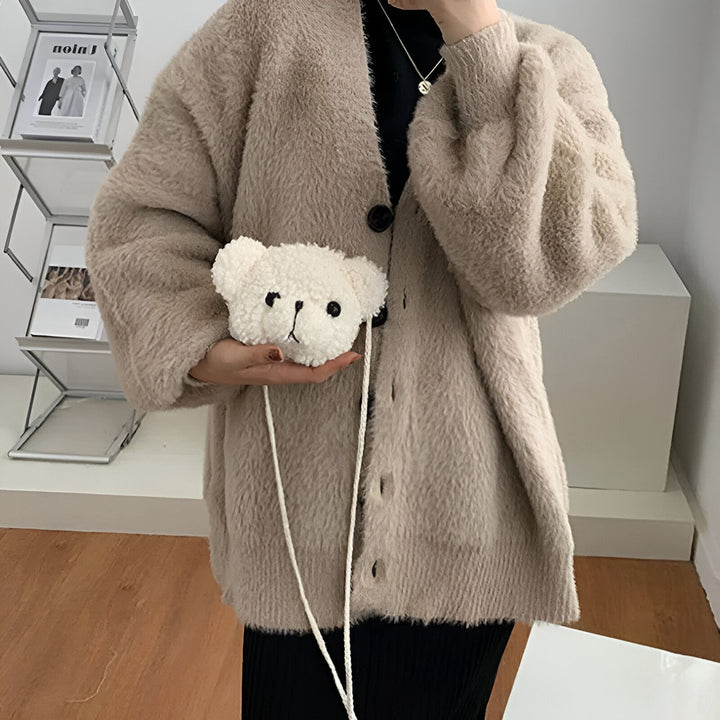 Sac blanc en forme de tête d'ours en peluche, tenu par une personne en gilet beige., 46193981587680,46193981620448