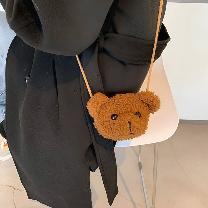 Petit sac en forme de tête d'ours marron porté avec un manteau noir., 46193981587680,46193981620448