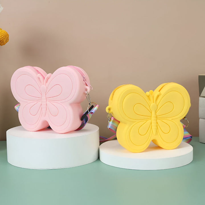 Deux sacs papillon en silicone rose et jaune avec lanières arc-en-ciel sur des supports blancs., 46193987289312,46193987322080,46193987354848,46193987387616