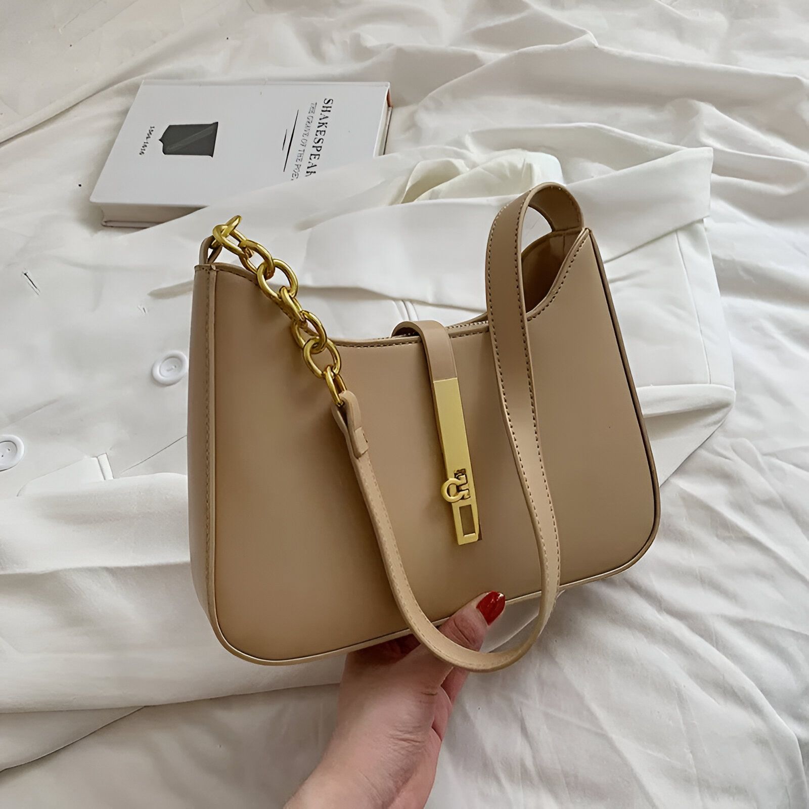 Un sac à main beige avec une chaîne dorée et un fermoir.