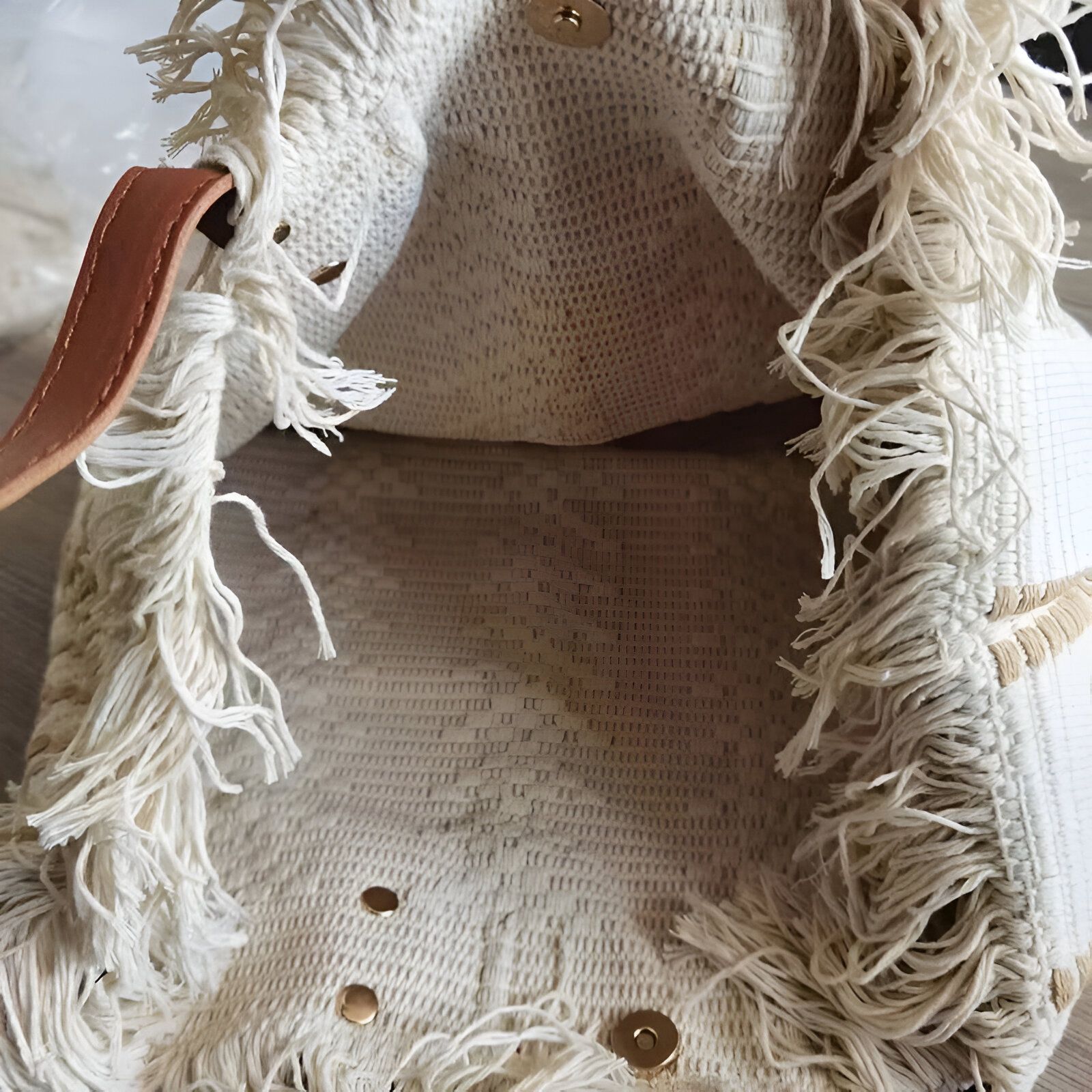 Sac à main en toile de jute avec des franges et une poignée en cuir marron.