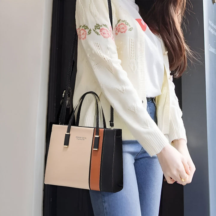 Sac à main tricolore beige, marron, noir porté par une femme., 46193873879264,46193873912032,46193873944800,46193873977568