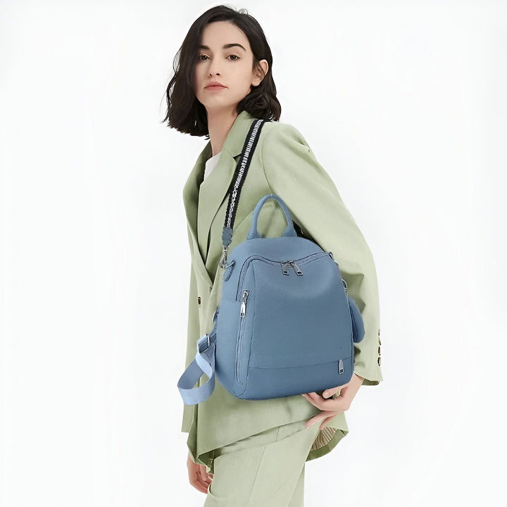 Femme en costume vert tenant un sac à dos bleu., 46193848680672,46193848713440,46193848746208,46193848778976,46193848811744,46193848844512