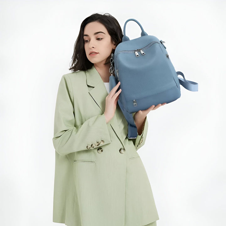 Femme en blazer vert tenant un sac à dos bleu, 46193848680672,46193848713440,46193848746208,46193848778976,46193848811744,46193848844512