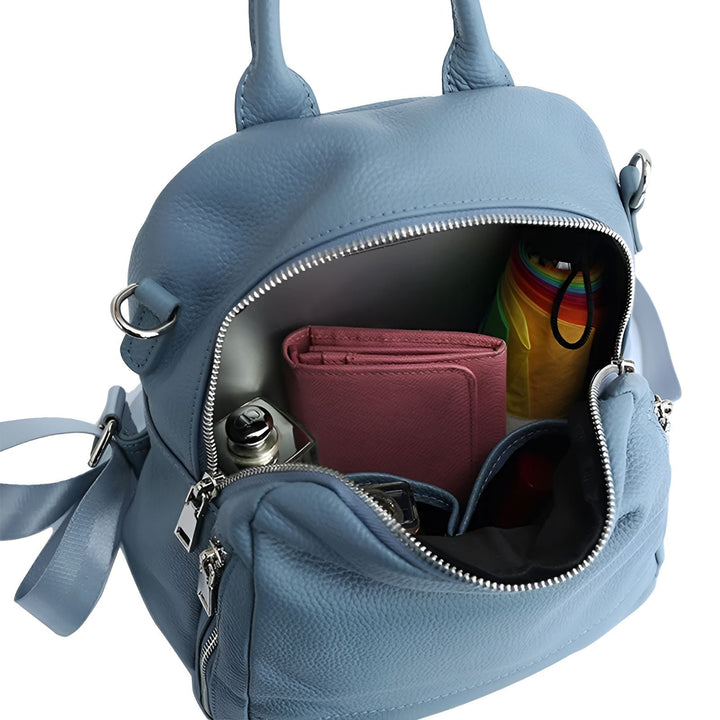 Sac à dos en cuir bleu ouvert avec portefeuille rose, bouteille de parfum et parapluie arc-en-ciel., 46193848680672,46193848713440,46193848746208,46193848778976,46193848811744,46193848844512
