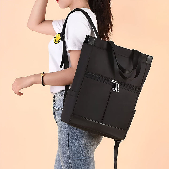 Femme portant un sac à dos noir en tissu et cuir avec poches zippées., 46193874665696,46193874698464,46193874731232,46193874764000