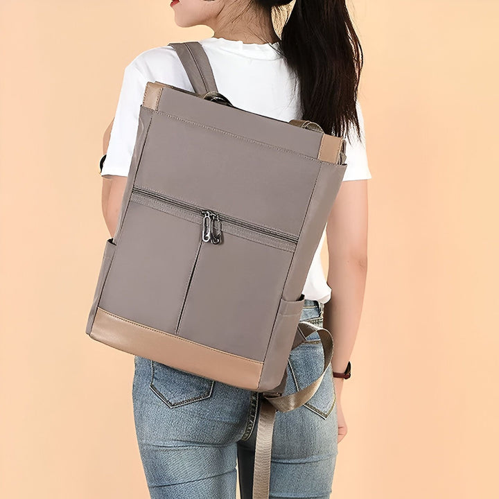 Personne de dos portant un sac à dos gris avec détails beige, 46193874665696,46193874698464,46193874731232,46193874764000