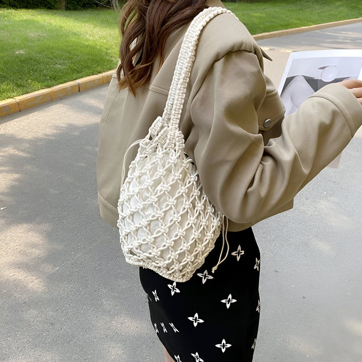 Sac macramé blanc porté épaule par une personne en veste beige et jupe noire motif., 46193948557536,46193948590304