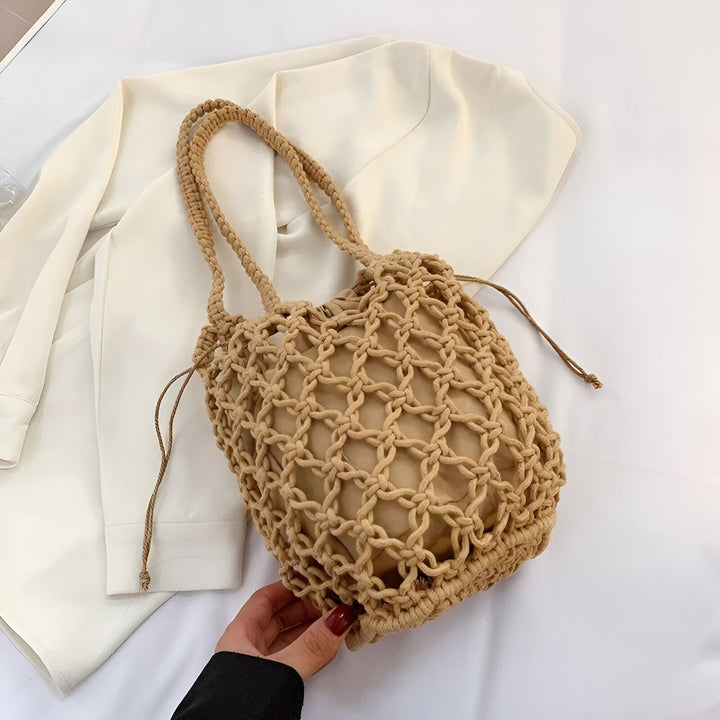 Sac cabas en maille beige avec doublure et cordon, tenu par une main, sur un vêtement crème., 46193948557536,46193948590304