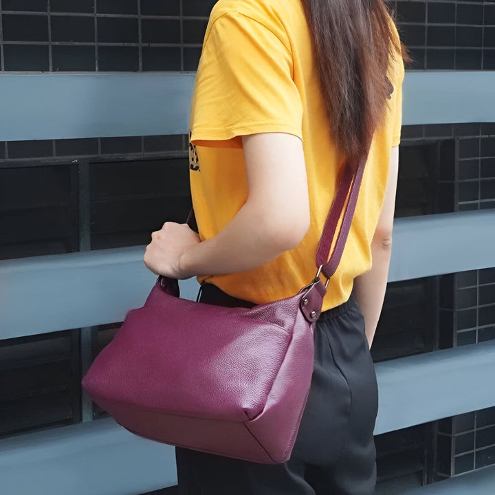 Femme vue de dos portant un sac à bandoulière en cuir violet et un t-shirt jaune., 46193842487520,46193842520288,46193842553056,46193842585824