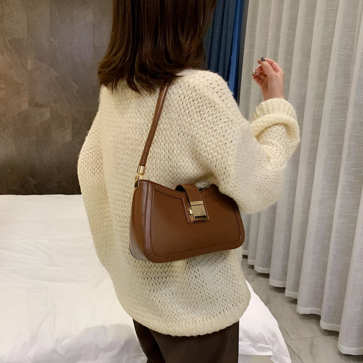Sac bandoulière marron avec boucle dorée porté par une femme en pull crème., 46193936236768,46193936269536,46193936302304,46193936335072