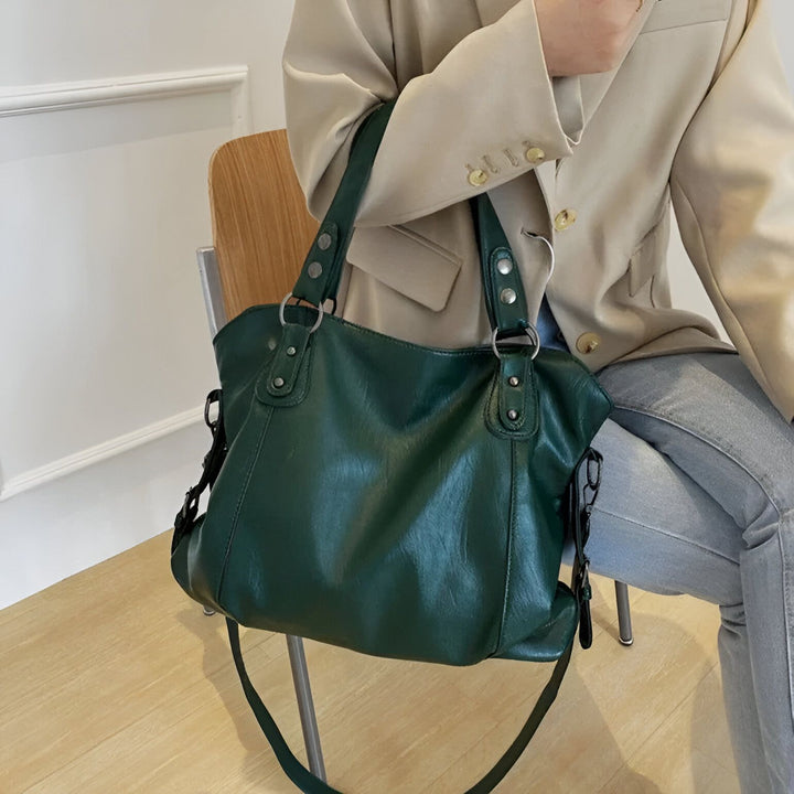 Sac à main vert foncé porté par une personne en blazer beige et jean., 46193878466784,46193878499552,46193878532320