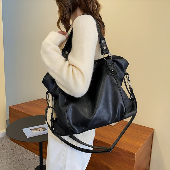 Femme en pull crème portant un grand sac noir en similicuir avec bandoulière., 46193878466784,46193878499552,46193878532320