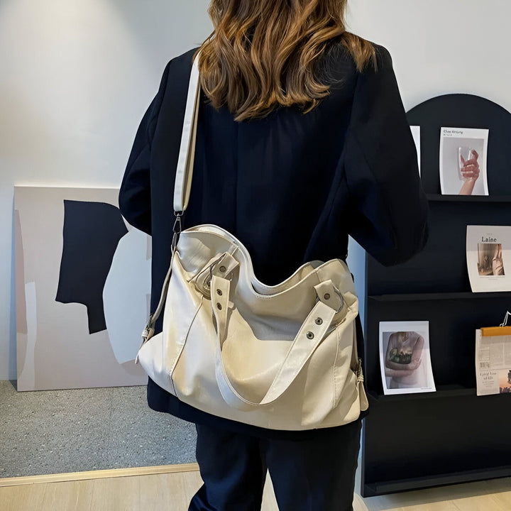Personne portant un grand sac tote bag beige clair sur l'épaule, vue de dos., 46193878466784,46193878499552,46193878532320