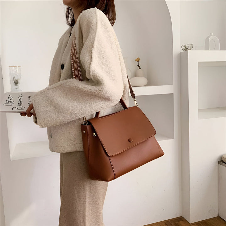 Sac bandoulière en cuir marron porté avec une veste crème., 46193884102880,46193884135648,46193884168416,46193884201184