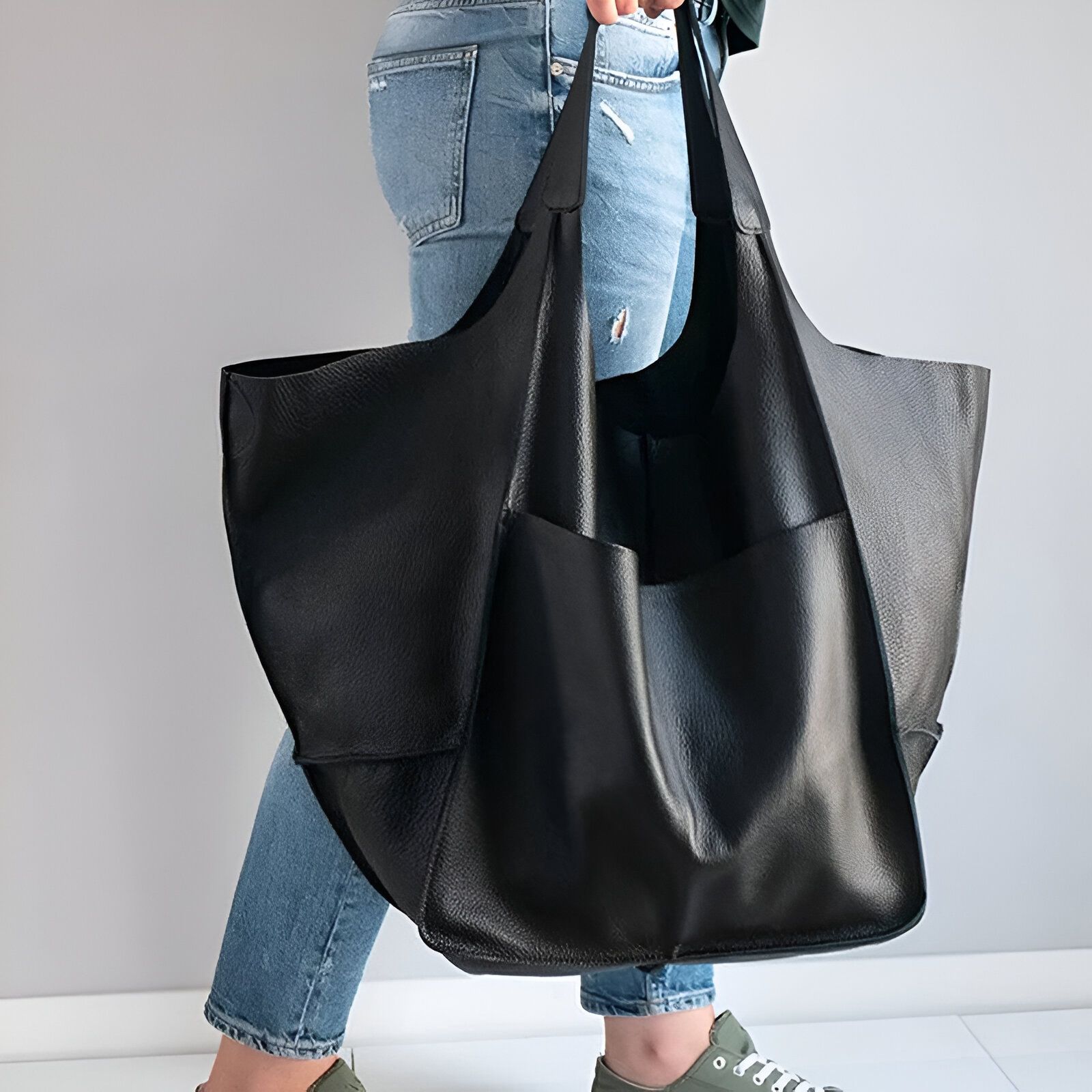 Un grand sac à main en cuir noir avec plusieurs poches.