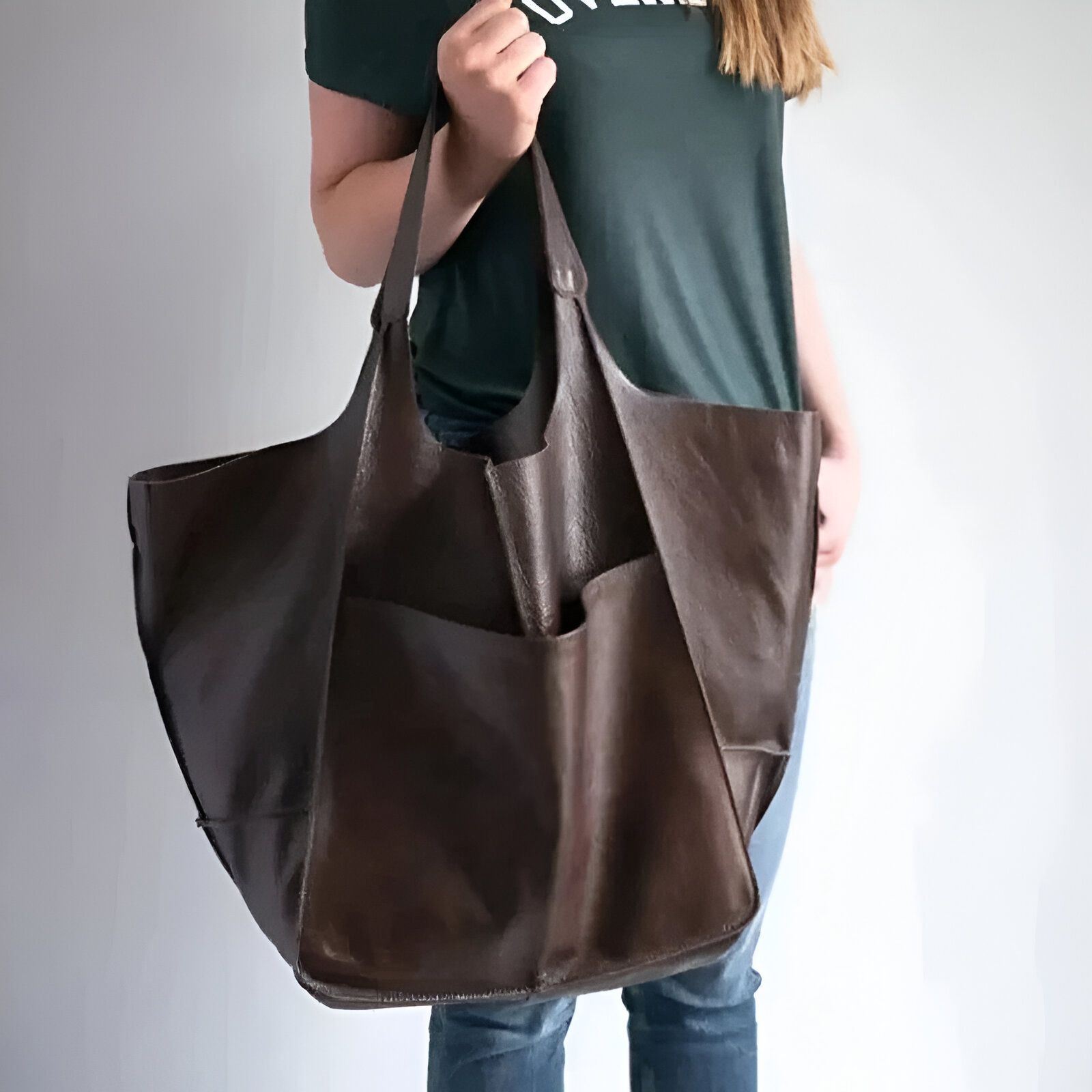 Un grand sac à main en cuir brun porté par une femme.