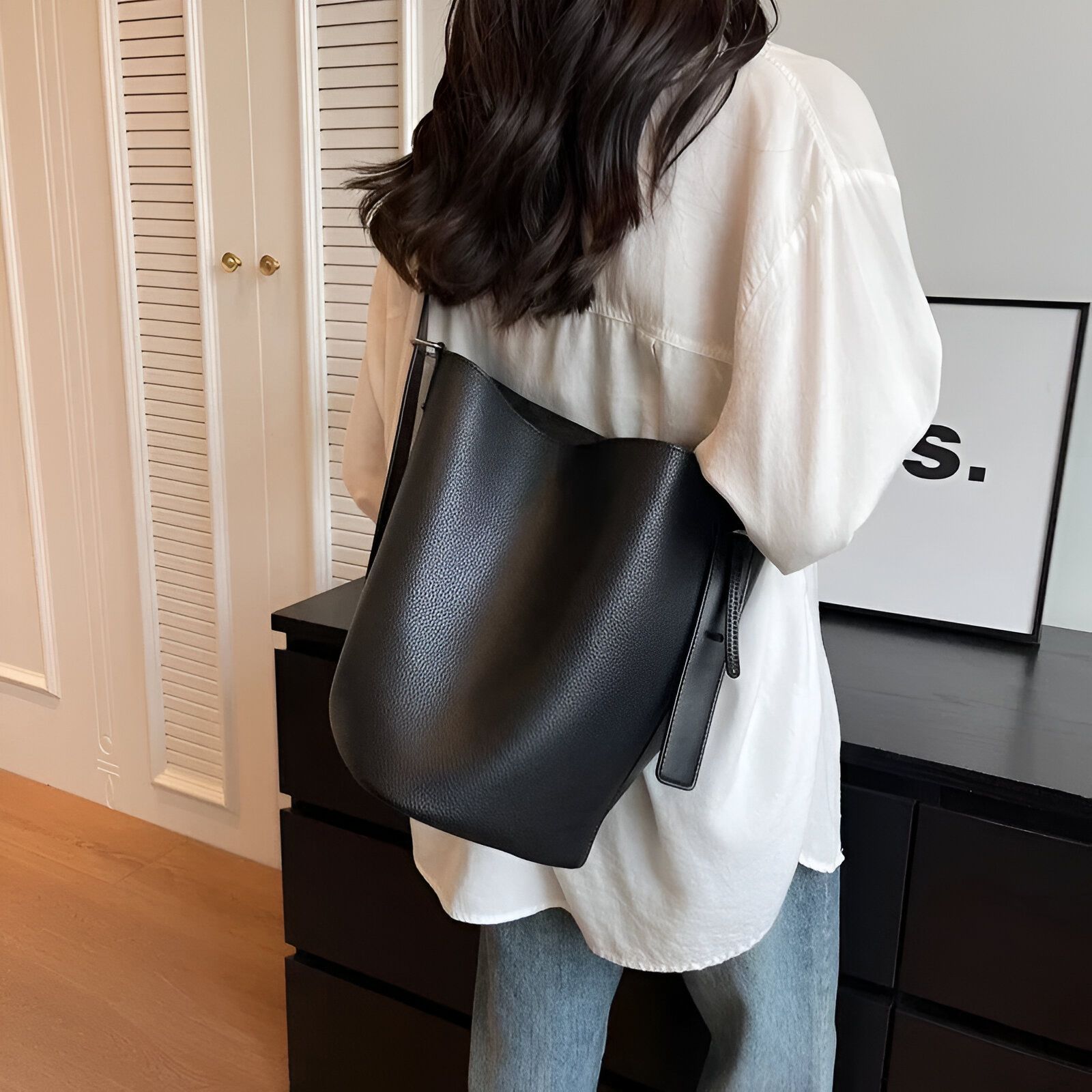 Une femme portant un sac à main noir en cuir.