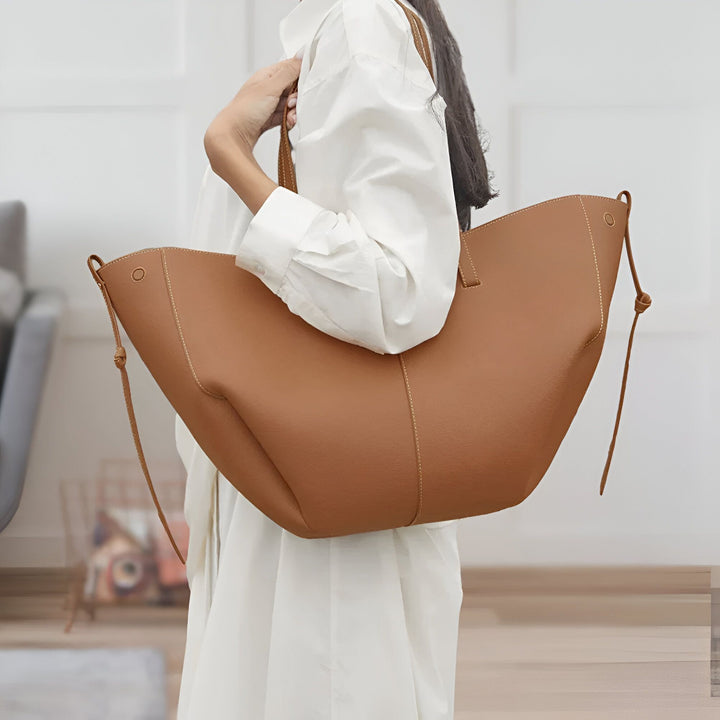 Sac cabas marron en cuir porté par une femme en chemise blanche., 46193882726624,46193882759392,46193882792160,46193882824928