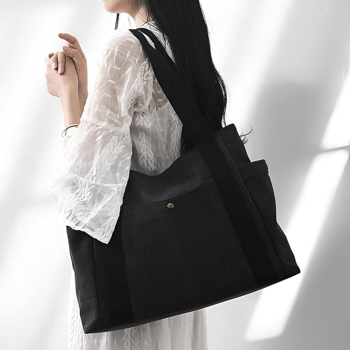 Femme portant un grand sac cabas noir sur l'épaule, 46193890590944,46193890623712