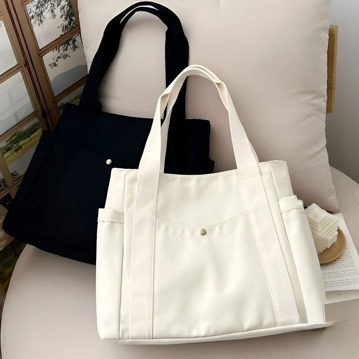 Deux sacs fourre-tout en toile, un noir et un blanc, sur un canapé, 46193890590944,46193890623712