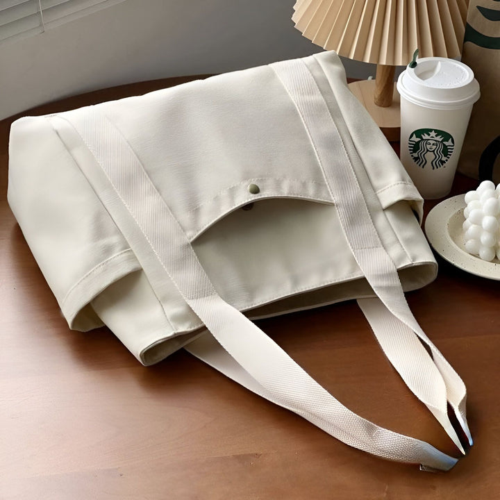 Sac tote bag crème avec larges bretelles, posé sur une table., 46193890590944,46193890623712