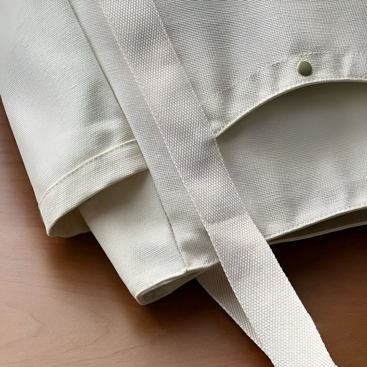 Gros plan sur un tissu blanc cassé texturé avec une sangle et un bouton pression., 46193890590944,46193890623712