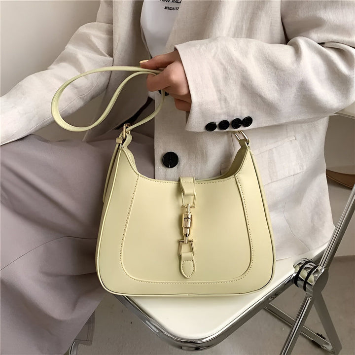 Sac à main jaune pâle tenu par une personne en veste claire., 46193934565600,46193934598368,46193934631136,46193934663904,46193934696672