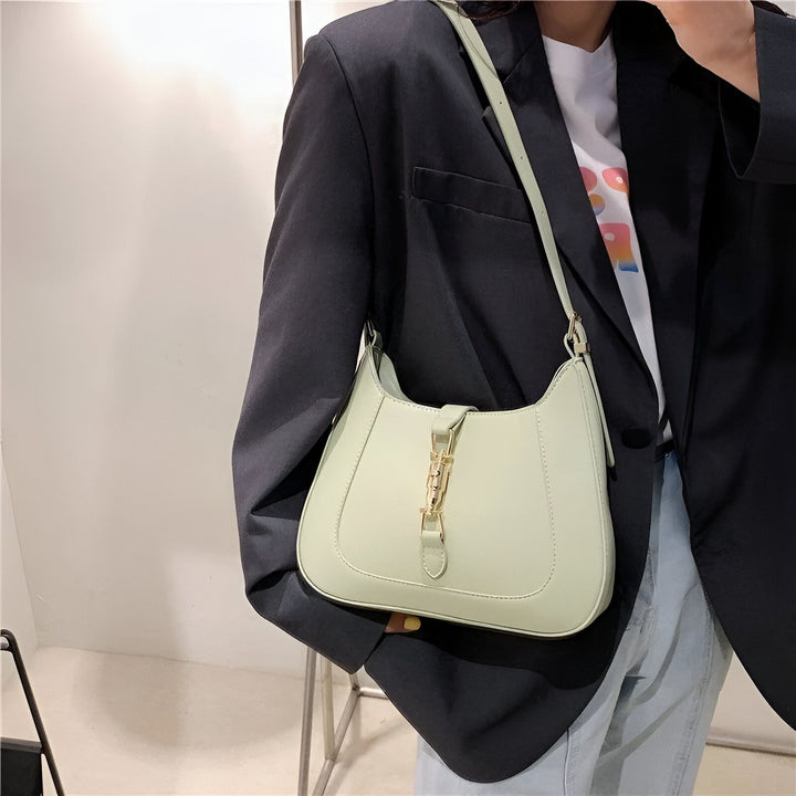 Personne portant un blazer noir avec un sac à bandoulière vert clair et une fermeture dorée., 46193934565600,46193934598368,46193934631136,46193934663904,46193934696672