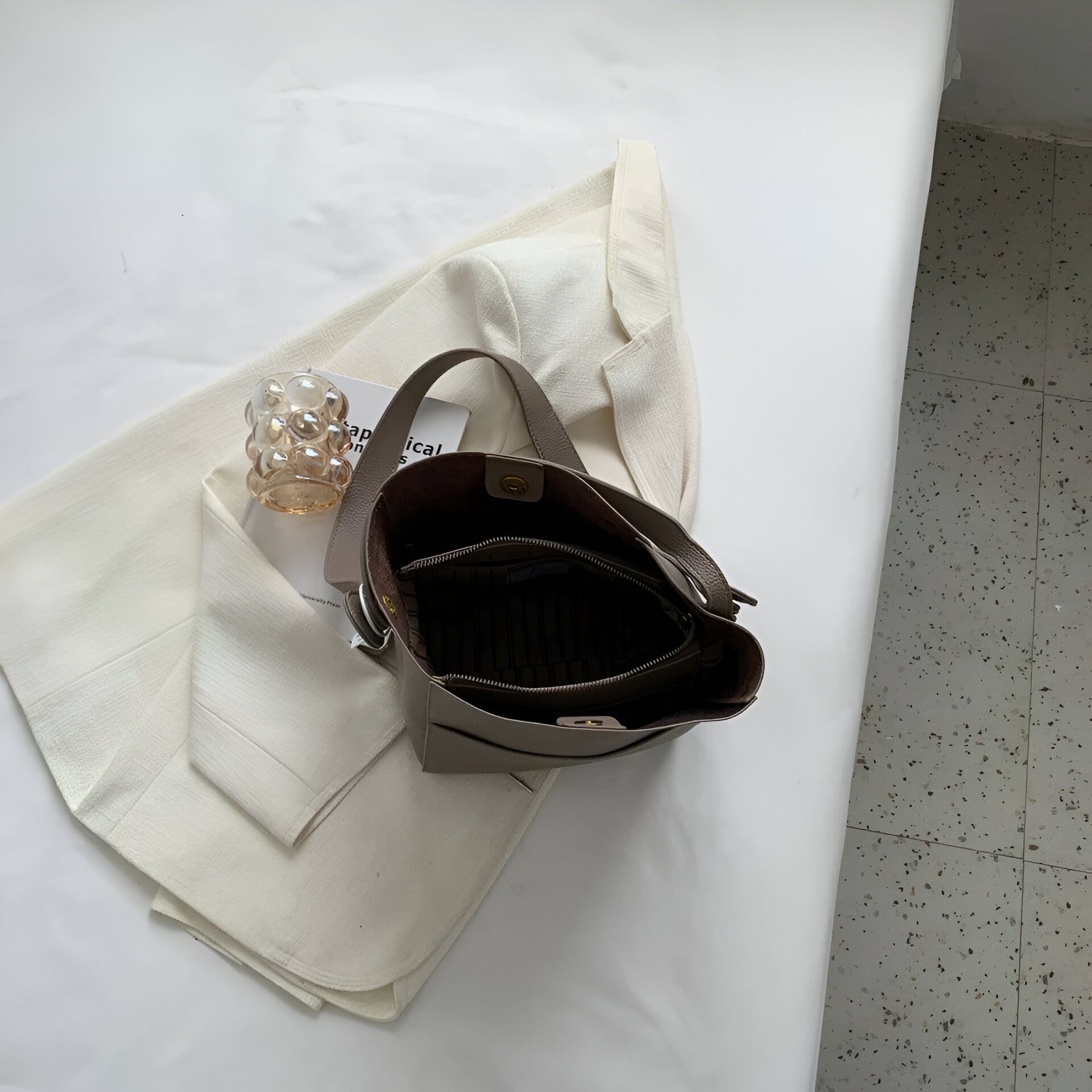 Un sac à main en cuir gris ouvert, montrant son intérieur.