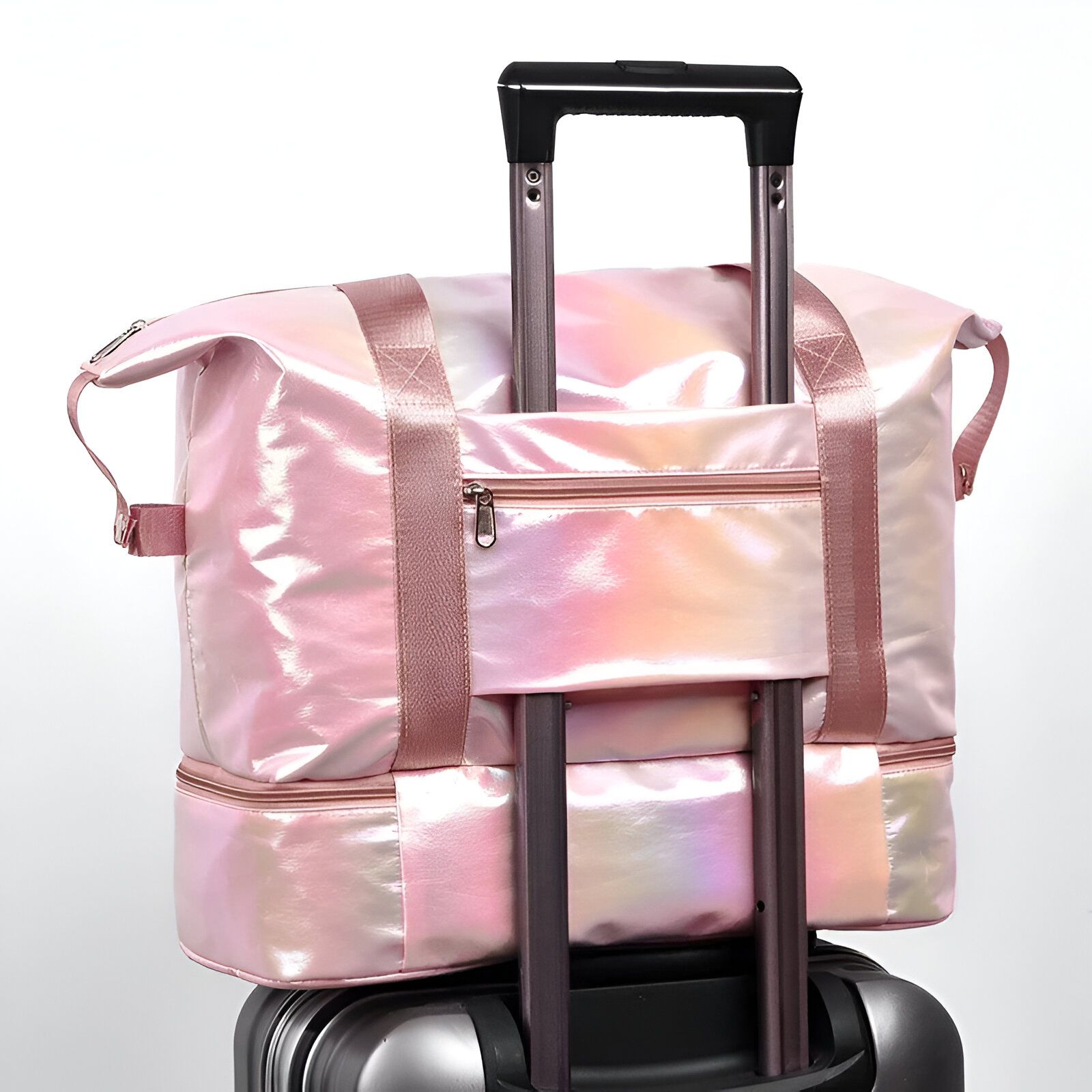 Sac de voyage rose pailleté avec une poignée télescopique, glissé sur la poignée d'une valise.