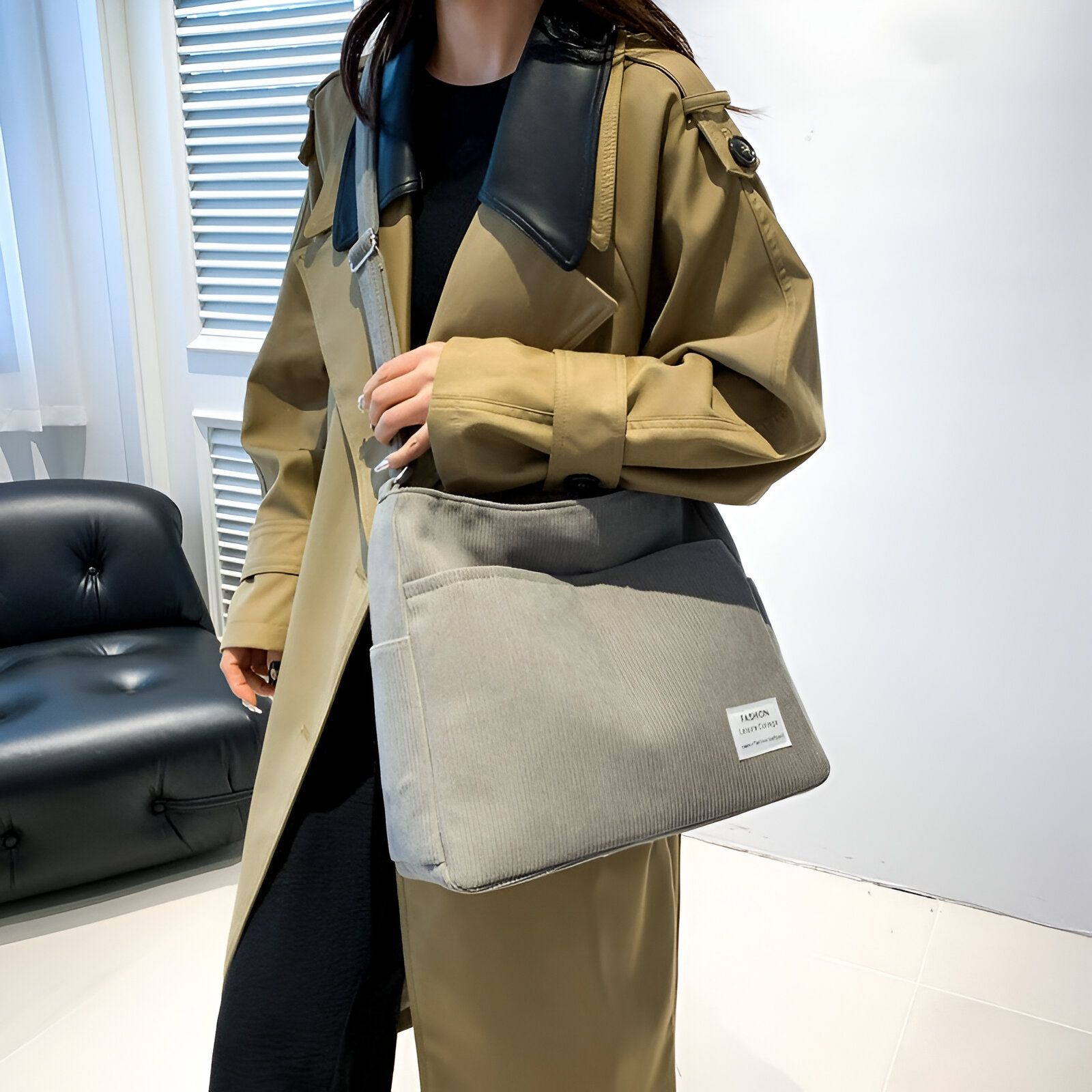 Une femme portant un manteau beige et un sac à bandoulière gris.