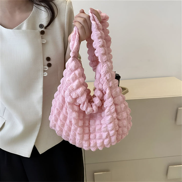 Sac à main rose pâle avec texture froncée tenu à la main., 46193876599008,46193876631776,46193876664544,46193876697312,46193876730080