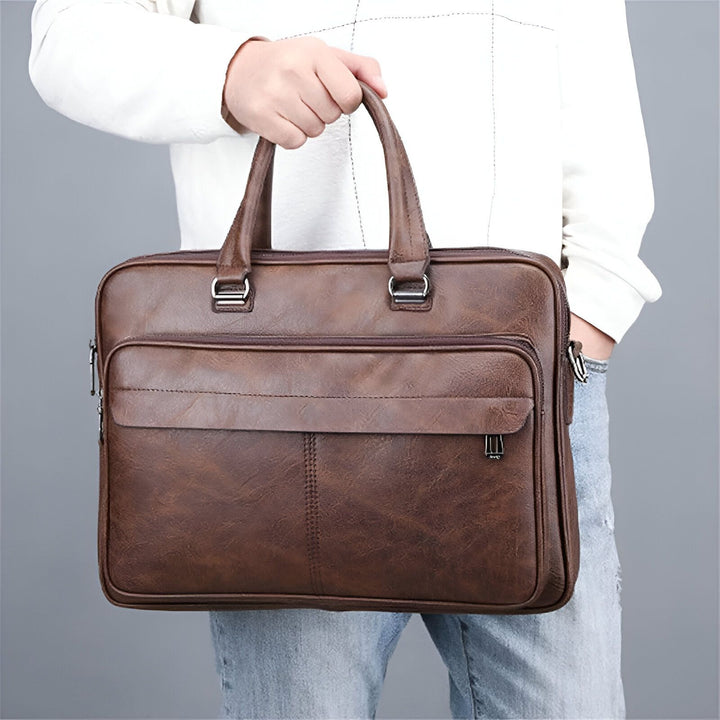 Homme tenant une mallette en cuir marron, 46194060132576,46194060165344,46194060198112