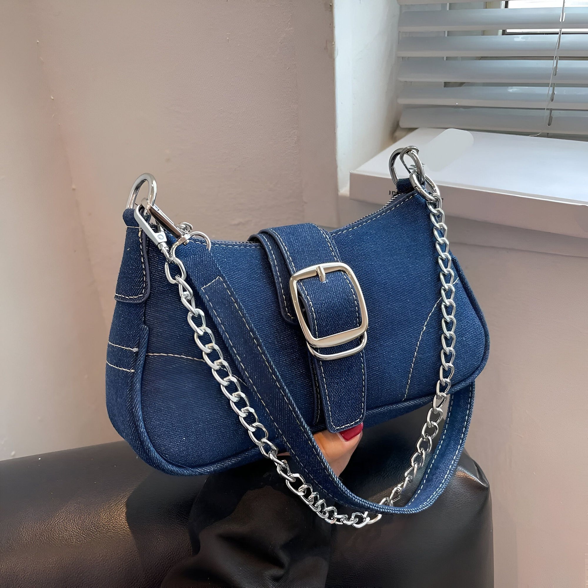 Sac à main en jean bleu avec une chaîne argentée.