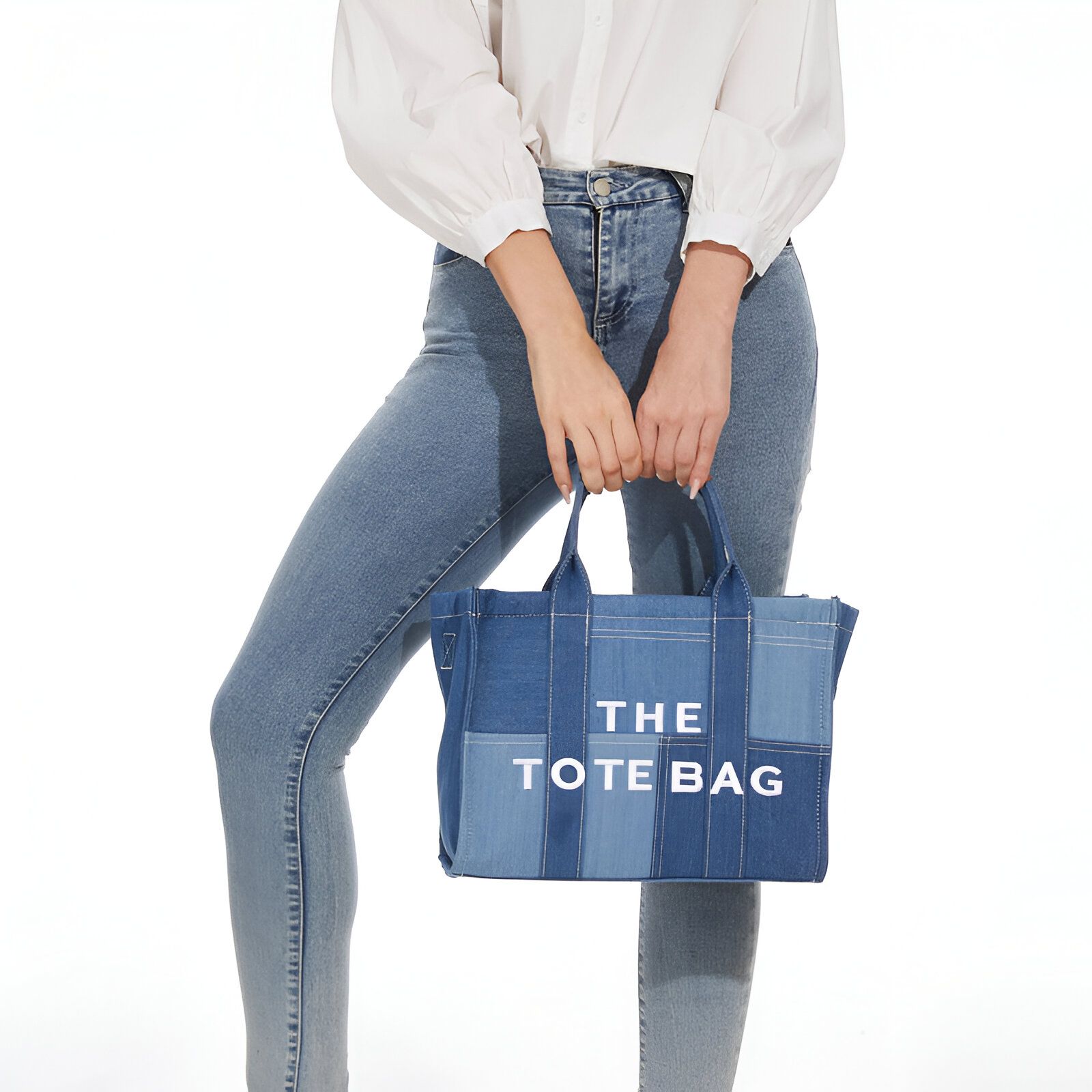 Une femme portant un jean bleu et un sac à main en jean avec l'inscription "The Tote Bag".