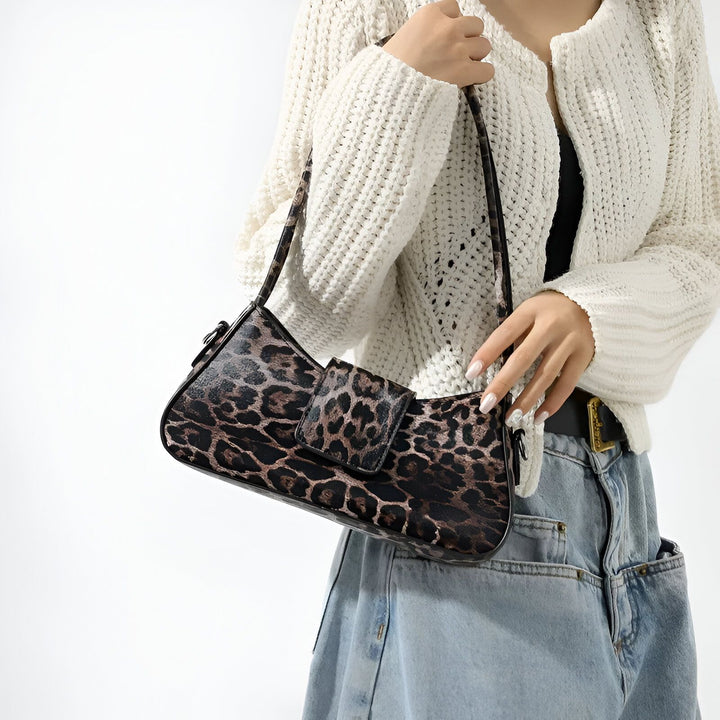 Sac bandoulière motif léopard tenu par une personne., 46193944035552,46193944068320,46193944101088