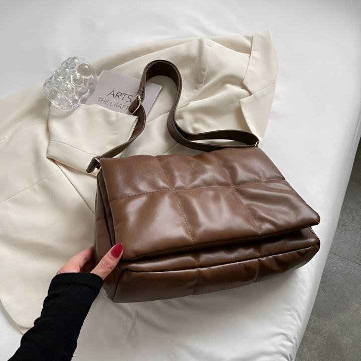 Sac bandoulière matelassé marron tenu en main près d'une veste blanche, 46193889476832,46193889509600,46193889542368,46193889575136