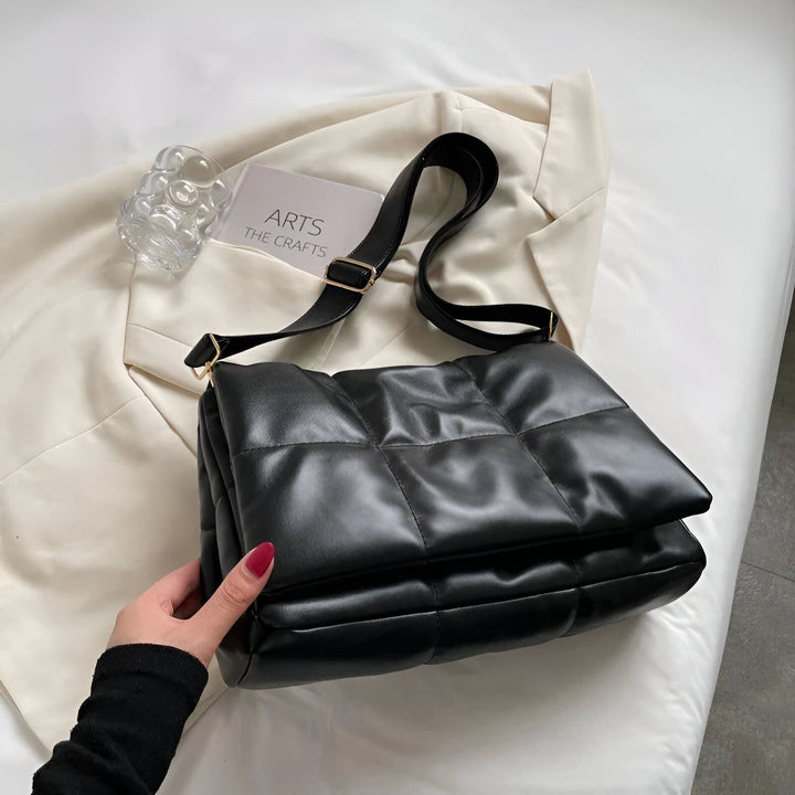 Sac bandoulière matelassé noir tenu par une main, 46193889476832,46193889509600,46193889542368,46193889575136