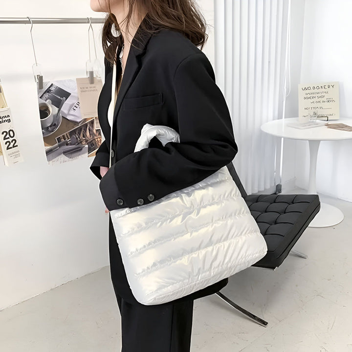 Sac tote blanc matelassé porté par une femme en blazer noir., 46193876926688,46193876959456,46193876992224,46193877024992,46193877057760
