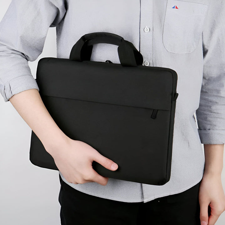 Personne tenant sous le bras une housse noire pour ordinateur portable avec poignée., 46193908744416,46193908777184,46193908809952,46193908842720,46193908875488,46193908908256,46193908941024,46193908973792,46193909006560,46193909039328,46193909072096,46193909104864