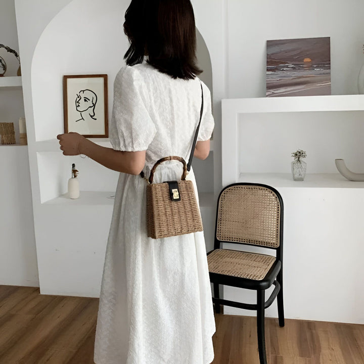 Sac tissé avec poignées bambou et bandoulière noire sur une femme en robe blanche., 46193945510112,46193945542880