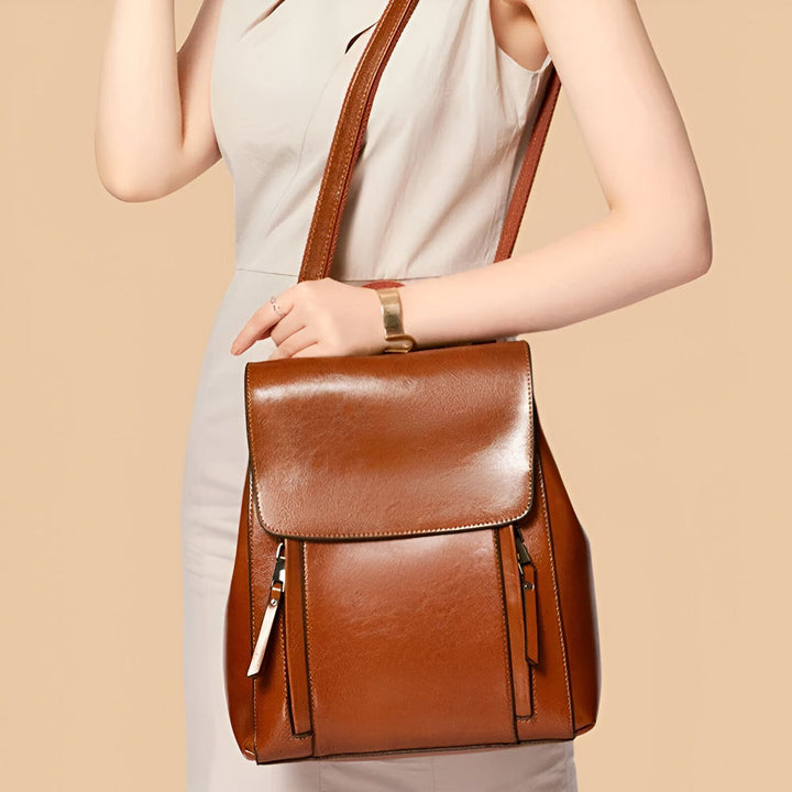 Sac à dos en cuir marron porté par une femme., 46193898586336,46193898619104,46193898651872