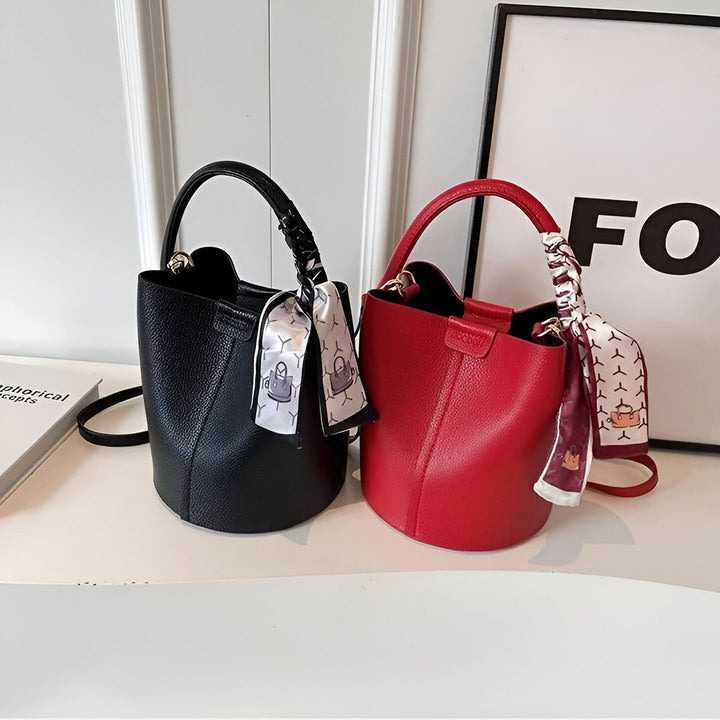 Deux sacs seaux, un noir et un rouge, avec des foulards décoratifs sur une surface blanche., 46194006720736,46194006753504